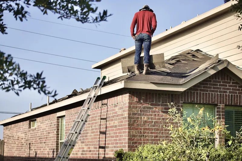 Professional roofer working on a residential roof in Pinewood Village